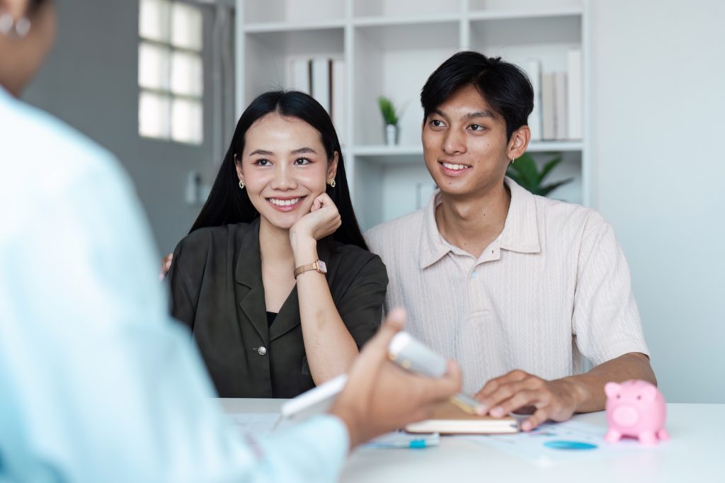 Young Couple Discussing Savings Plans with Financial Advisor in Modern Office Setting